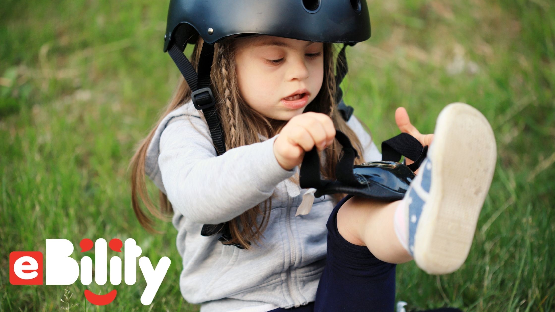 girl with downs syndrome putting on shin pads and helmet